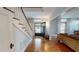 A foyer with hardwood floors, open black front door and staircase with white banisters at 308 College St, Oxford, NC 27565