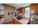 Charming kitchen featuring wood cabinets, brick accent wall, and modern stainless steel appliances at 308 College St, Oxford, NC 27565