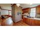 Spacious kitchen with brick accent wall, custom wood cabinets, and seamless dining area access at 308 College St, Oxford, NC 27565