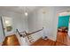 Upstairs landing with wood floors, railing and access to bedroom and bathroom at 308 College St, Oxford, NC 27565