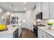 Modern kitchen featuring white cabinets, stainless steel appliances and a large kitchen island at 312 Providence Creek Dr, Fuquay Varina, NC 27526