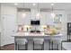 Modern kitchen with white cabinets, quartz countertop, and large kitchen island with seating at 312 Providence Creek Dr, Fuquay Varina, NC 27526