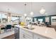 Open-concept kitchen and living room with modern lighting and teal accent wall at 312 Providence Creek Dr, Fuquay Varina, NC 27526