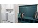 Convenient mud room with built-in bench, storage cubbies, and a nearby laundry area with modern appliances at 312 Providence Creek Dr, Fuquay Varina, NC 27526