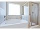 Bright bathroom with a soaking tub under a window and separate glass-enclosed shower at 34 E American Marigold Dr # 64, Benson, NC 27504