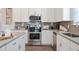 Gourmet kitchen featuring stainless appliances, granite countertops, and white cabinets at 34 E American Marigold Dr # 64, Benson, NC 27504