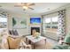 Cozy living room featuring plush seating, fireplace, ceiling fan, and large windows with natural light at 39 Atherton Circle, Angier, NC 27501