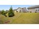 View of the backyard, with a sloped lawn and a small patio area at 4102 Catfish Way, Durham, NC 27703