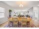 Open-concept dining area with a rustic table, colorful rug, and views into the bright and comfortable living room at 4102 Catfish Way, Durham, NC 27703
