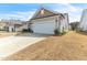 View of the two-car garage and a well-maintained lawn with carefully placed plants and shrubbery at 4102 Catfish Way, Durham, NC 27703