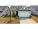 Inviting home featuring a two-car garage, neutral siding, manicured lawn and complementary landscaping at 4102 Catfish Way, Durham, NC 27703