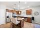 Stylish kitchen features stainless steel appliances, granite countertops, island with seating, and wooden cabinetry at 4102 Catfish Way, Durham, NC 27703