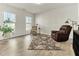 Cozy living room with a leather armchair, area rug, and ample natural light from the two windows at 4102 Catfish Way, Durham, NC 27703