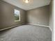 A simple carpeted bedroom features a window offering natural light at 414 Longfellow St, Fuquay Varina, NC 27526