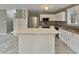 Kitchen featuring an island with white cabinets, stainless steel appliances, and updated flooring at 414 Longfellow St, Fuquay Varina, NC 27526