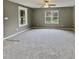Spacious carpeted living room bathed in natural light from large windows, with overhead fan at 414 Longfellow St, Fuquay Varina, NC 27526