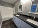 Well-lit bathroom featuring a double vanity, granite countertops, and tub/shower at 427 Elm Ct, Burlington, NC 27215