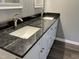 Close up on the bathroom vanity with black granite countertop at 427 Elm Ct, Burlington, NC 27215