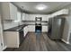 Modern kitchen with stainless steel appliances, white cabinets, and sleek black countertops at 427 Elm Ct, Burlington, NC 27215