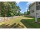 Large, fenced backyard with lush green grass and mature trees, perfect for outdoor activities at 45 Pebble Creek Dr, Franklinton, NC 27525