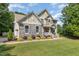 Side view of a two-story home featuring stone and shingle siding, an attached garage, and lush green landscaping at 45 Pebble Creek Dr, Franklinton, NC 27525
