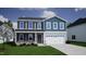 Charming two-story home with blue siding, stone accents, and a two-car garage at 46 Atherton Circle, Angier, NC 27501