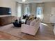 Bright living room with hardwood floors, a comfortable sofa, and large windows at 46 Atherton Circle, Angier, NC 27501