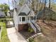 View of the home's charming exterior, brick foundation, front stairs, driveway, and surrounding yard at 4724 Worchester Pl, Raleigh, NC 27604