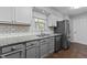 Close-up of a kitchen with stainless steel appliances, granite countertops, tile backsplash, and hardwood floors at 4724 Worchester Pl, Raleigh, NC 27604
