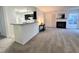 Open living area with a fireplace and a breakfast bar flowing to the kitchen at 4907 Hollenden Dr # 105, Raleigh, NC 27616