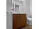 Small half bathroom with a wooden vanity and mirror, plus a white toilet at 5620 Hamstead Xing, Raleigh, NC 27612