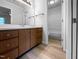 Bright bathroom with wood vanity and mirror, and a toilet in the adjacent room at 5620 Hamstead Xing, Raleigh, NC 27612