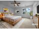 Bright bedroom features a wooden bed frame, a ceiling fan and a window view at 5620 Hamstead Xing, Raleigh, NC 27612