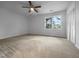 A bedroom with beige carpet, a window, and a ceiling fan is empty and ready for a new tenant at 5620 Hamstead Xing, Raleigh, NC 27612