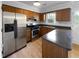 Full kitchen with stainless steel appliances, wooden cabinets, and granite countertops at 5620 Hamstead Xing, Raleigh, NC 27612