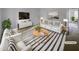 Bright staged living room featuring a white couch, chairs and striped area rug at 5620 Hamstead Xing, Raleigh, NC 27612