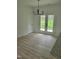 Dining area with wood floors, modern lighting, and glass door access to backyard at 5710 Russell Rd, Durham, NC 27712