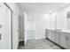 Bathroom showcases gray wood-look floors and double vanity with gray cabinets at 601 White Birch Ln, Angier, NC 27501