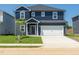 Two-story home with blue siding, white trim, a front-facing two-car garage, and a well-maintained front yard at 601 White Birch Ln, Angier, NC 27501