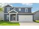 Two-story home featuring a two-car garage and blue siding, and a well maintained lawn at 601 White Birch Ln, Angier, NC 27501