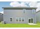 Rear exterior showcasing a sliding glass door, neat siding, well-placed windows, and a patch of green grass at 601 White Birch Ln, Angier, NC 27501