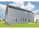 Rear exterior view displaying neat gray siding, a sliding glass door, and well-maintained green grass at 601 White Birch Ln, Angier, NC 27501