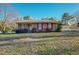 Charming brick home with a manicured lawn and detached garage in the background at 604 Orange Factory Road, Bahama, NC 27503