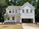 Charming two-story home featuring a welcoming front porch, attached garage and manicured front yard with mature tree at 61 Atherton Circle, Angier, NC 27501