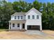 New two-story home showcasing white siding, multiple windows, and an attached two-car garage at 61 Atherton Circle, Angier, NC 27501