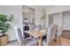 Bright dining room with a wooden table, upholstered chairs, large mirror, and floral arrangement on a stylish sideboard at 62 Atherton Circle, Angier, NC 27501