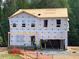 New two-story home featuring pre-construction with building materials and exposed beams in a wooded area at 62 Atherton Circle, Angier, NC 27501