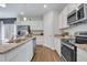 Modern kitchen with white cabinets, stainless steel appliances, granite countertops, and wood-look flooring for a stylish look at 62 Atherton Circle, Angier, NC 27501