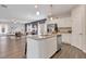 Open-concept kitchen with stainless steel appliances, granite countertops, and island, seamlessly flowing into the living area at 62 Atherton Circle, Angier, NC 27501