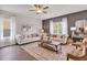 Cozy living room features stylish decor, comfortable seating, a ceiling fan, a patterned rug, and lots of natural light at 62 Atherton Circle, Angier, NC 27501